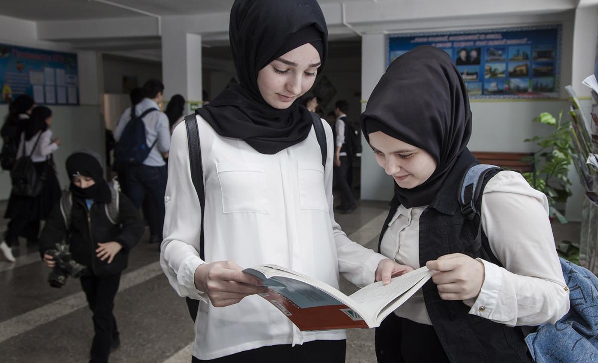 Two girls are reading a book