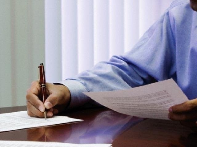 man writes on paper