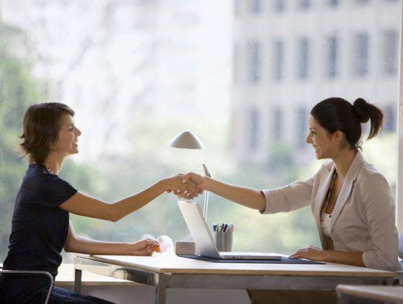 Two women shake hands
