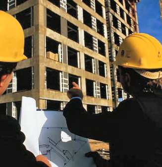 men in helmets look at the construction site